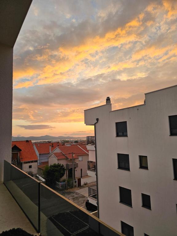uma vista para o pôr-do-sol a partir da varanda de um edifício em Luxury Penthouse with seaview and parking em Zadar