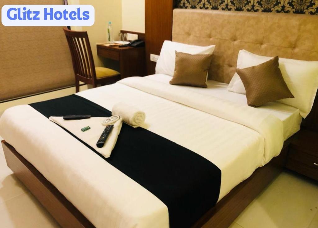 Habitación de hotel con cama con mando a distancia en 7even Hills- International Airport By Glitz Hotels en Bombay