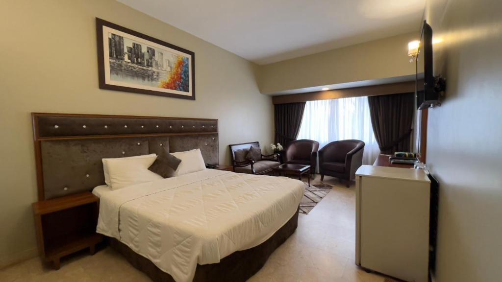 Faran Hotel في كراتشي: غرفه فندقيه فيها سرير وكراسي