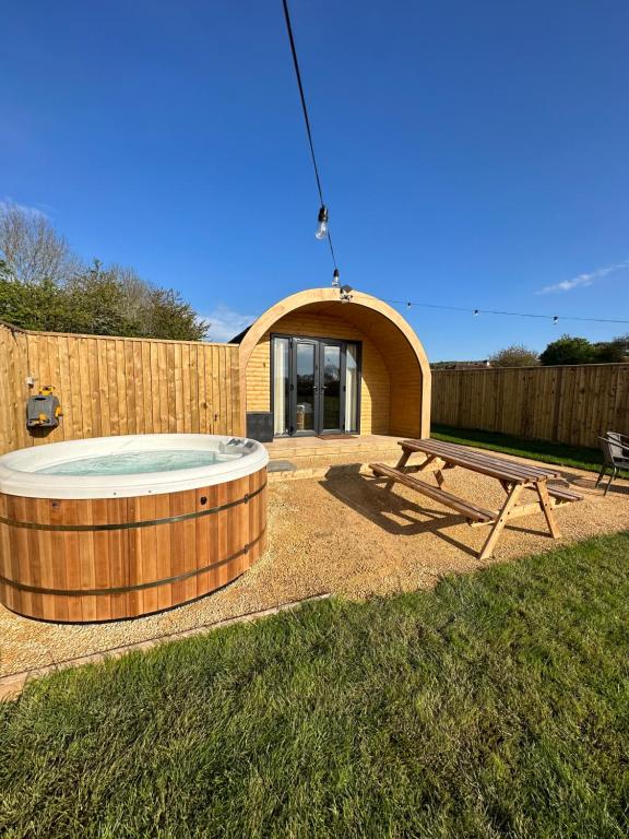 a backyard with a hot tub and a picnic table at Lois' Pod with Hot Tub, Near Airport in Bristol
