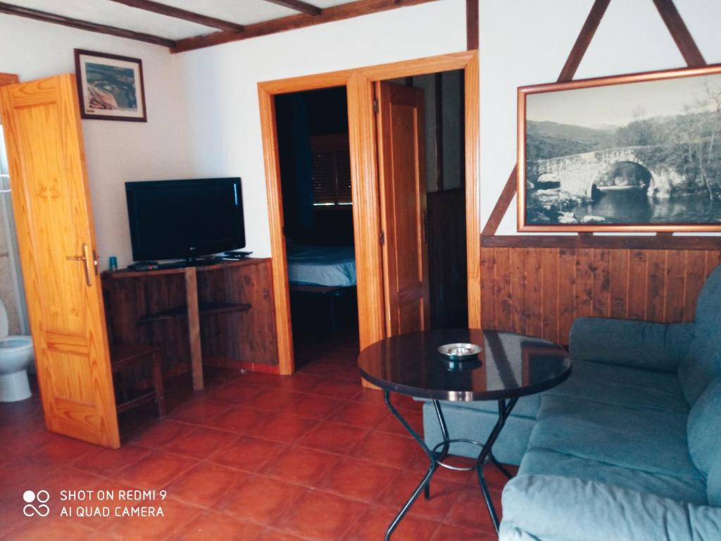 a living room with a couch and a table at Complejo Godoy in Losar de la Vera