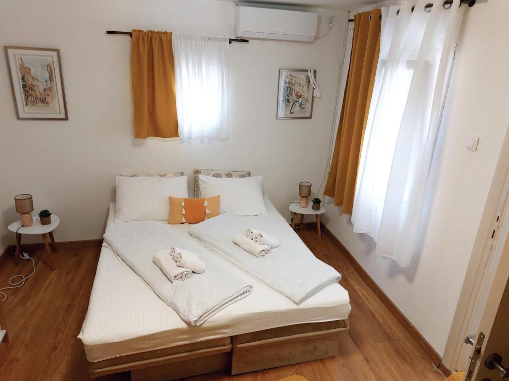 ein Schlafzimmer mit einem Bett mit Handtüchern darauf in der Unterkunft Ljubovic apartman in Podgorica