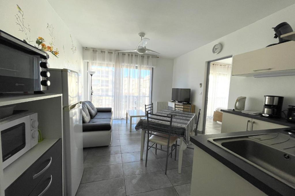 une cuisine et un salon avec un canapé et une table dans l'établissement Balaruc Les Bains Charmant T2, 2 pas des Thermes, à Balaruc-les-Bains