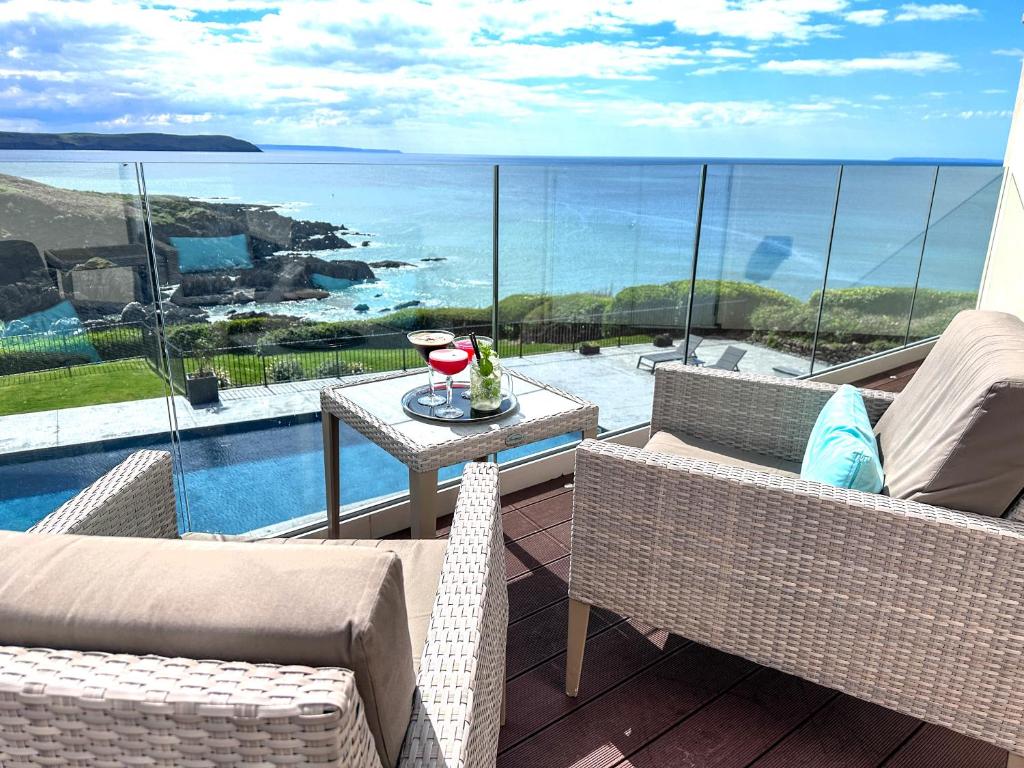a balcony with a table and chairs and a view of the ocean at Watersmeet Hotel in Woolacombe