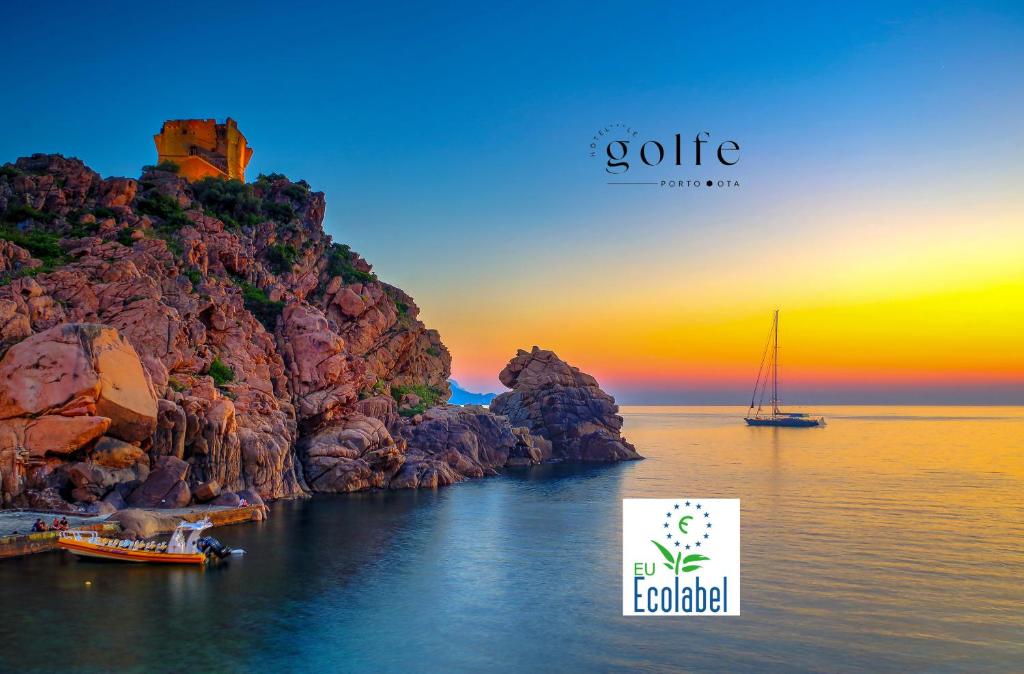 a boat on the water next to a rocky island at Hôtel Le Golfe Ecolabel EU in Porto Ota