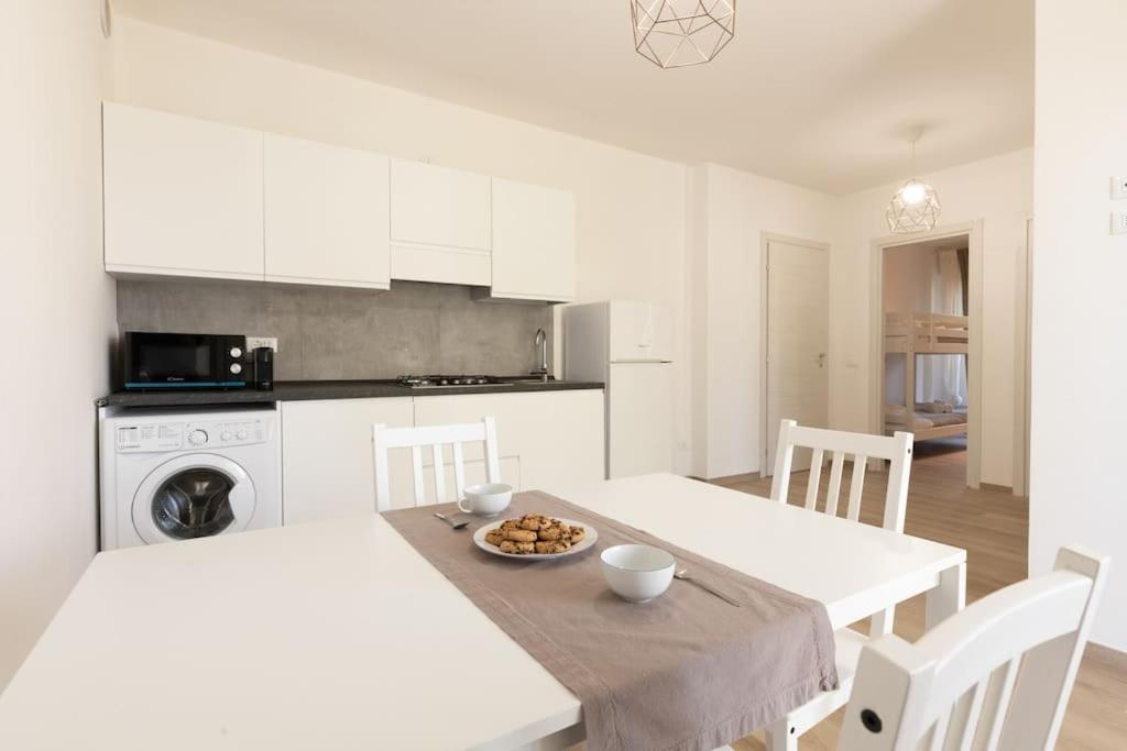 a white kitchen with a table and white cabinets at Al Mare da Lù in Riccione