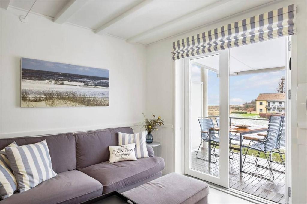 un salon avec un canapé et une terrasse avec une table dans l'établissement Holiday Apartment With Ocean View, à Hals