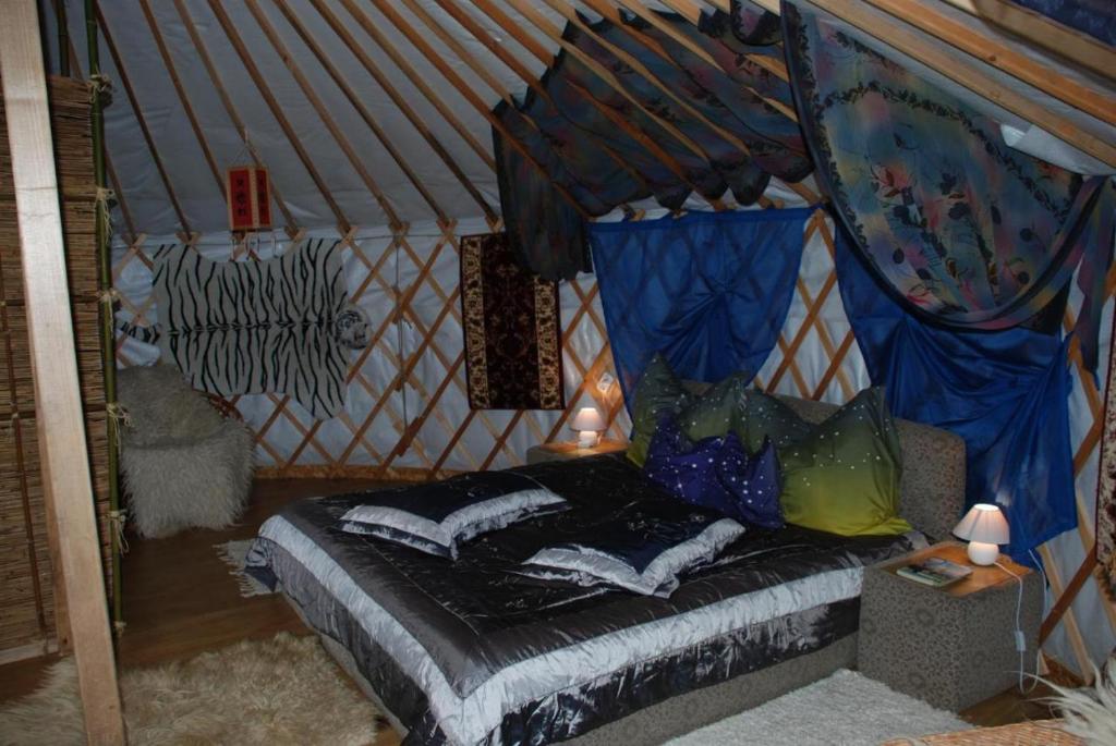 1 dormitorio con 1 cama en una tienda de campaña en Mennyország Jurta Hotel 