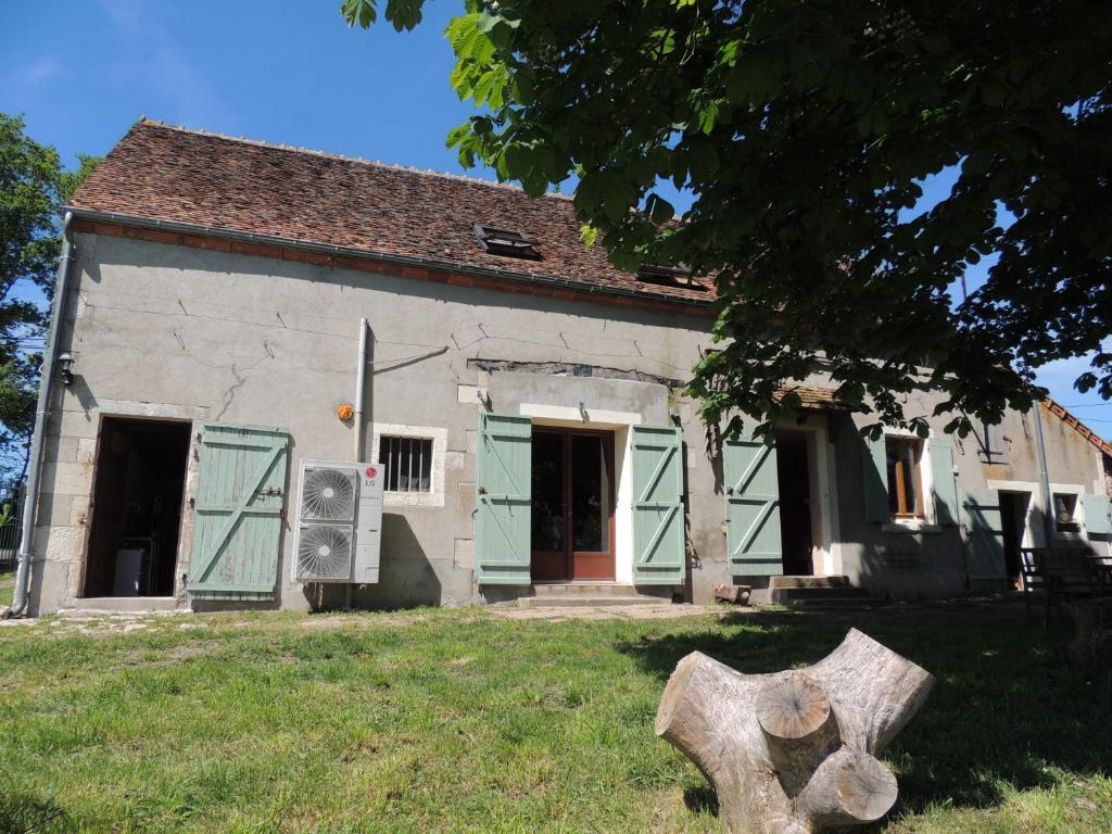 ein altes Haus mit grünen Türen und Baumstumpf in der Unterkunft Rêves et Chaudrons in Vicq-Exemplet