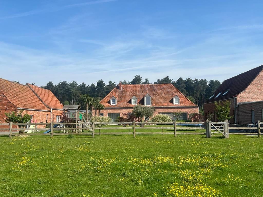 a group of houses in a field with green grass at B&B DeSo in Zonnebeke