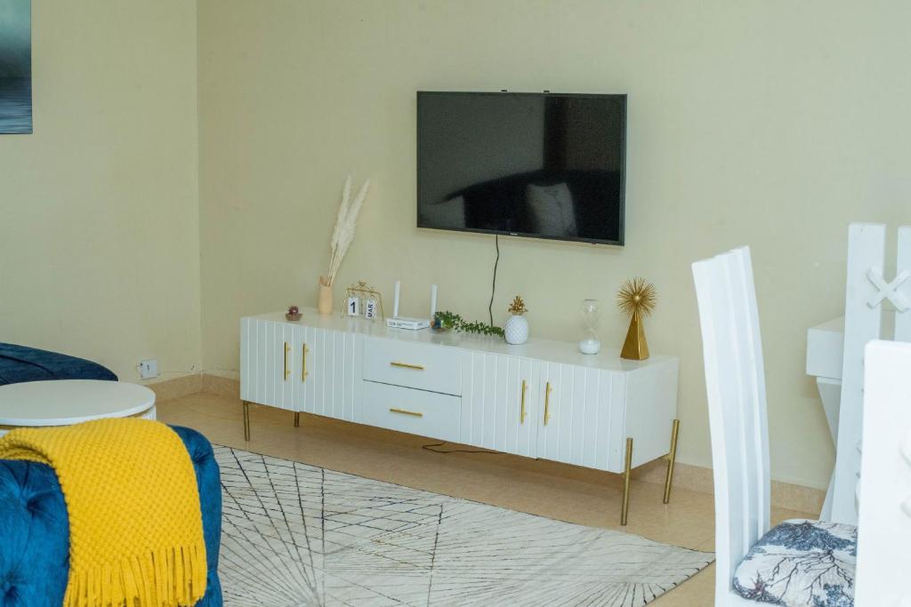 ein Wohnzimmer mit einem weißen Schrank und einem TV darauf in der Unterkunft Eldoret home, Q10 unity homes in Eldoret