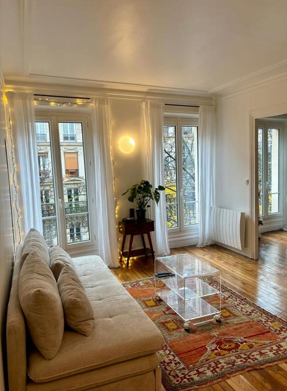 un salon avec un canapé et une table en verre dans l'établissement Cosy appartement Montmartre, à Paris
