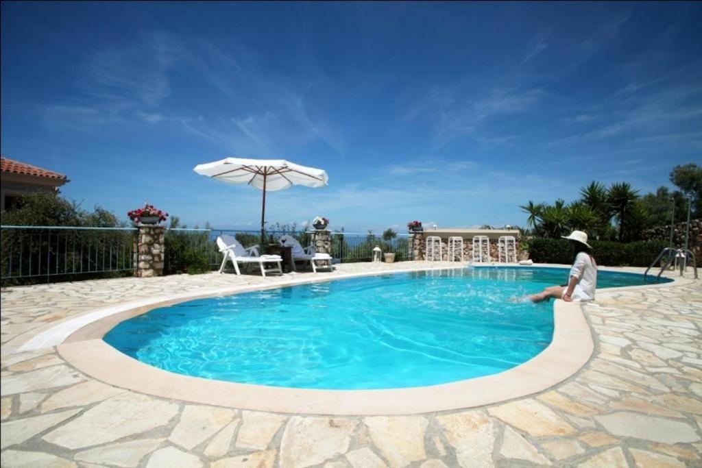 una persona está de pie junto a una piscina en Villa Elenia, en Tsoukaladhes