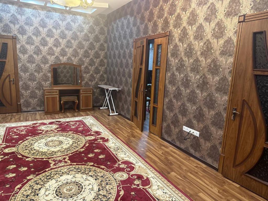 ein Wohnzimmer mit einem Teppich und ein Zimmer mit einem Tisch in der Unterkunft NL hotel in Yakkasaray