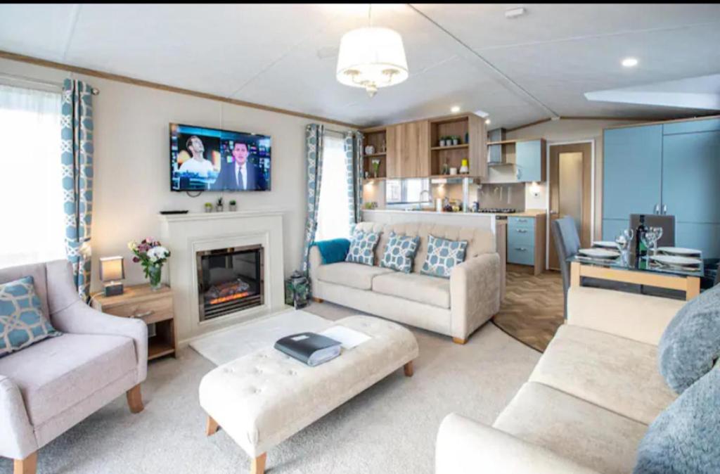 sala de estar con 2 sofás y chimenea en Beautiful 3-Bed Lodge in St Andrews, en St Andrews
