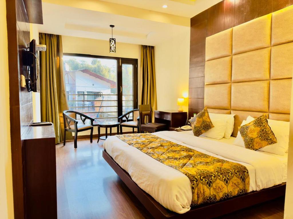 um quarto de hotel com uma cama e uma varanda em Radiance valley Resort - A peaceful stay em Mai Jūbar
