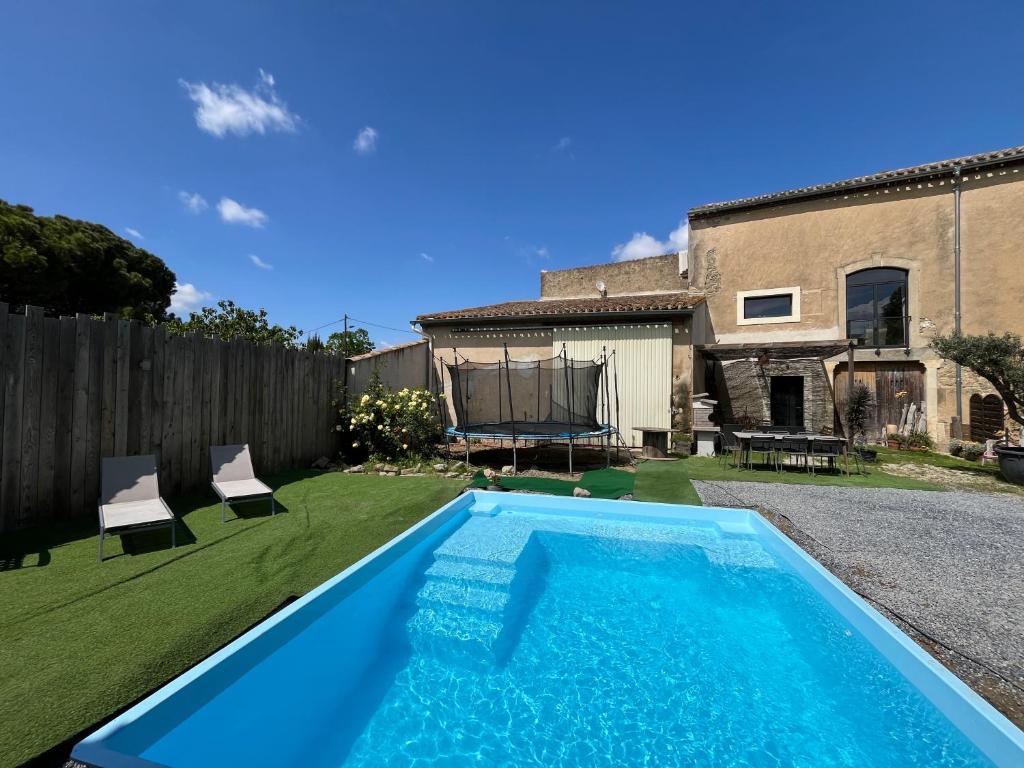 a swimming pool in the backyard of a house at Loft Chocolatine, spacieux, piscine, trampoline in Carcassonne