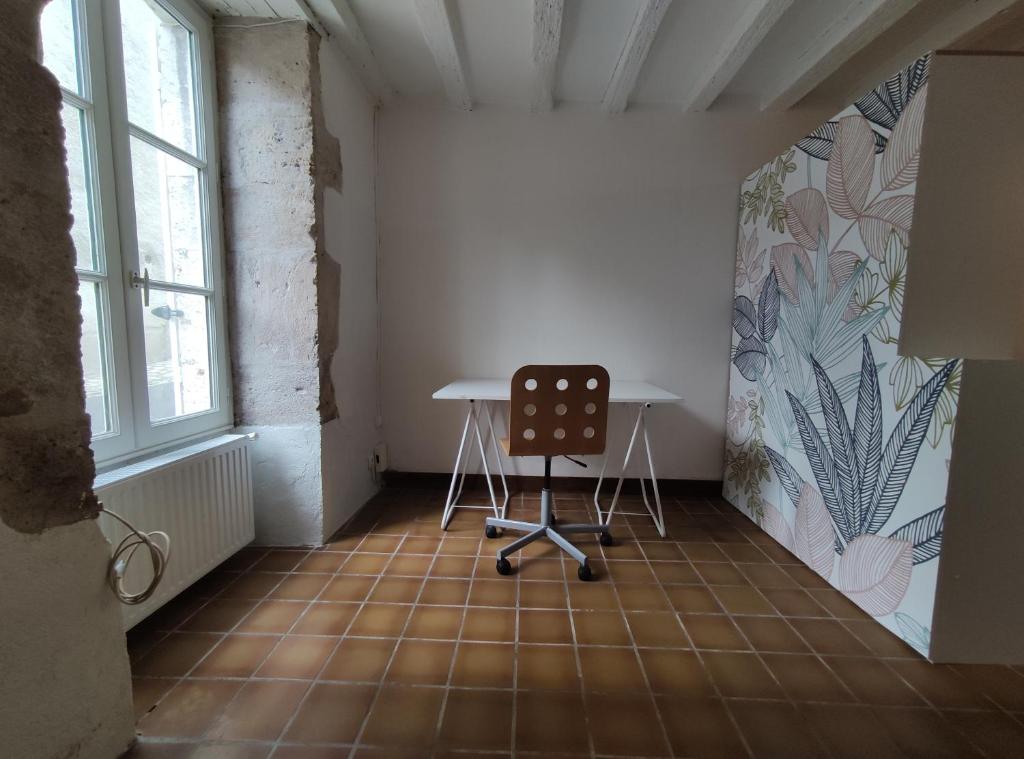 Cette chambre comprend une table et une chaise. dans l'établissement Appartement Blois centre ville, à Blois