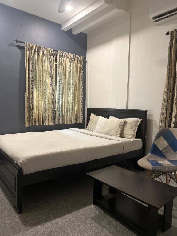 1 dormitorio con cama, mesa y ventana en HOTEL BLUESTONE, en Coimbatore