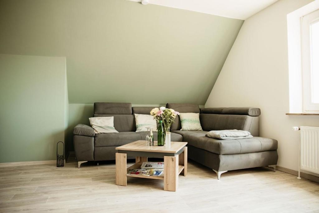 a living room with a couch and a coffee table at Ferienwohnung Hohner Seeblick in Hohn