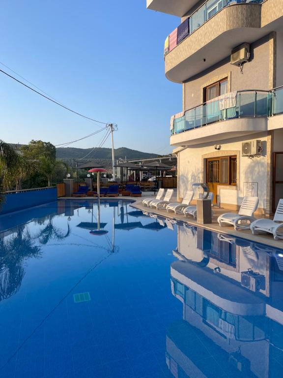 a swimming pool with chairs and a building at Vila Anna in Ksamil