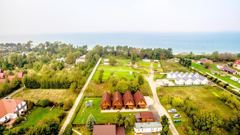 an aerial view of a village with houses and the ocean at Domki u Jacola Gąski in Gąski
