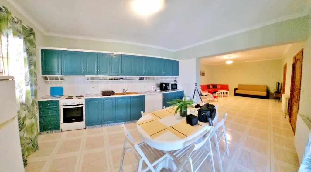 a kitchen with blue cabinets and a table and chairs at Emma's Studios in Lassi