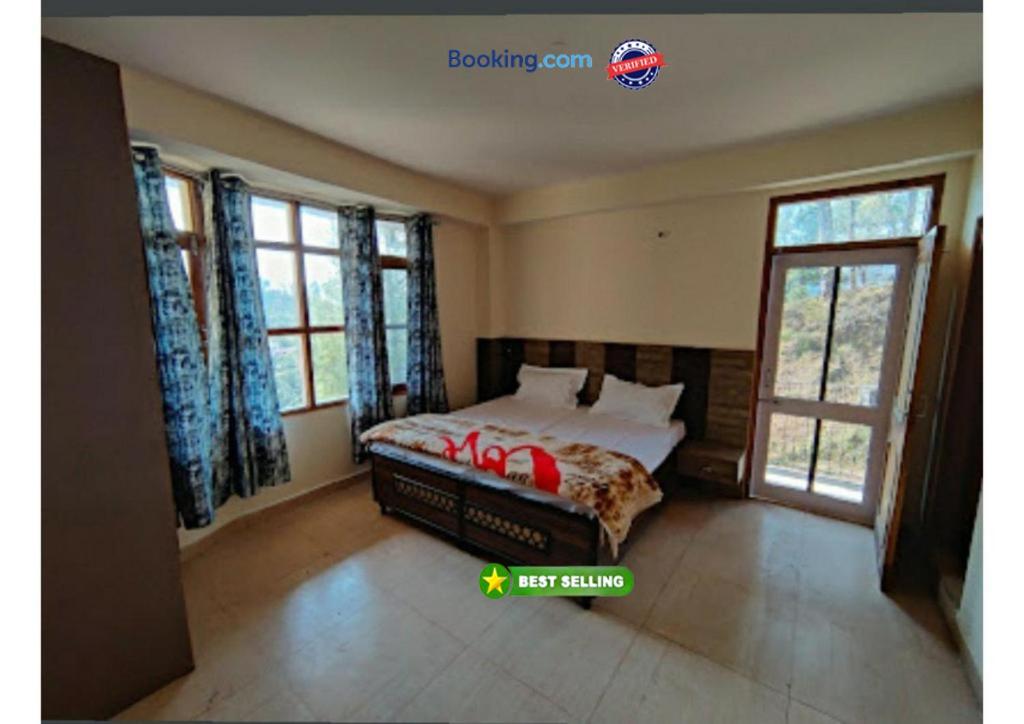 sypialnia z łóżkiem w pokoju z oknami w obiekcie Hotel Gopi Dham Ashram Haridwar Near Vrindavan w mieście Haridwar