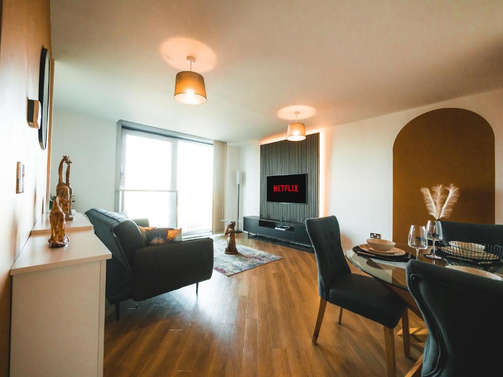 sala de estar con mesa y sillas y sala de estar con en The Safari Suite Luxury Apartment Milton Keynes en Milton Keynes