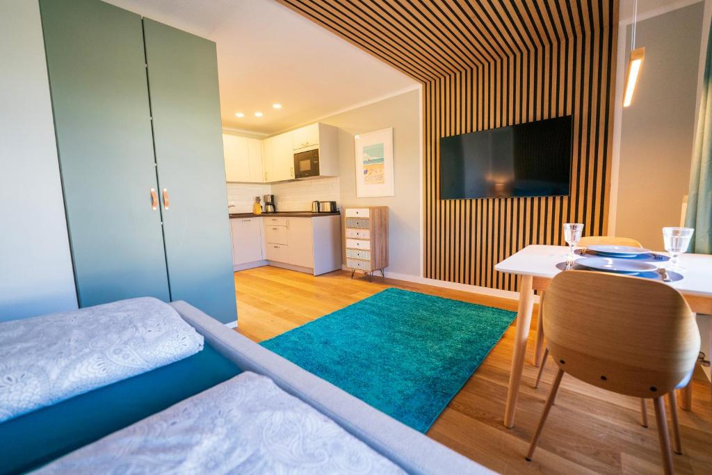 ein Schlafzimmer mit einem Bett und einem Tisch sowie eine Küche in der Unterkunft Strand11 Hochwertige Ferienwohnungen Ahlbeck in Ahlbeck