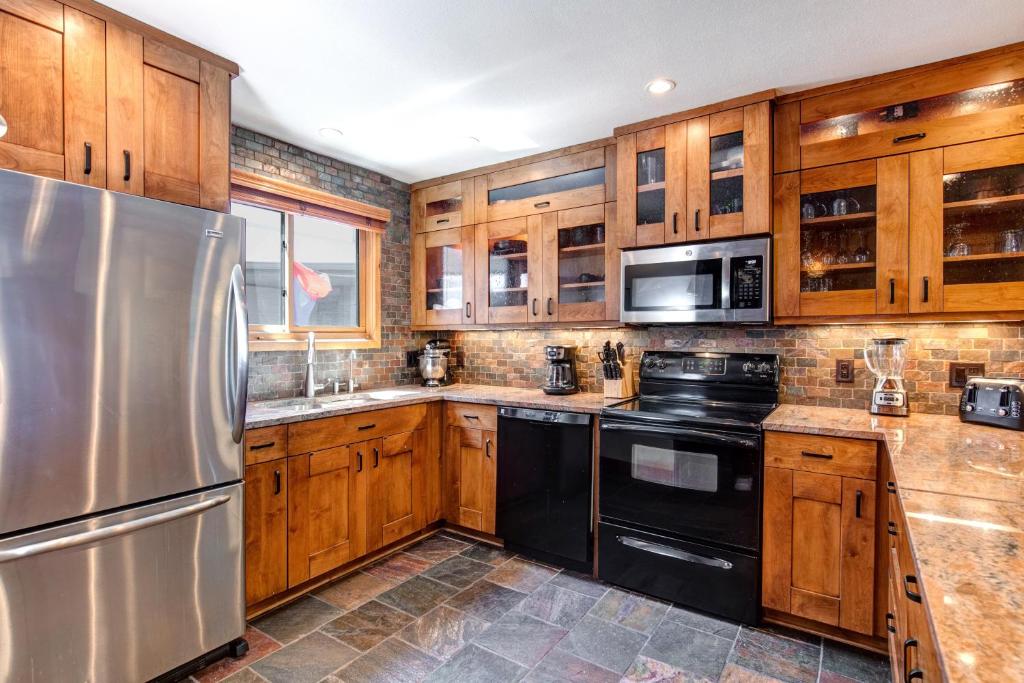 a kitchen with wooden cabinets and a stainless steel refrigerator at SNOW FLOWER 029 condo in Park City