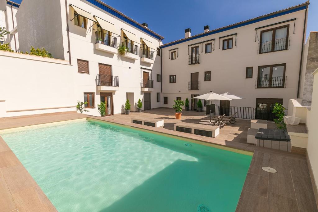 a swimming pool in front of a building at Coello31 - Apartamento céntrico y tranquilo, con piscina y parking in Jaén