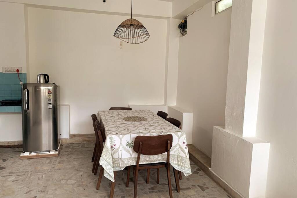 a kitchen with a table with chairs and a refrigerator at One Bedroom in C-Scheme, Jaipur in Jaipur