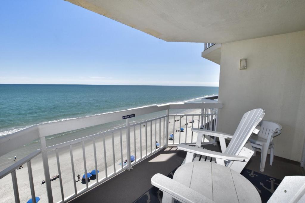 uma varanda com duas cadeiras e o oceano em 0804 Waters Edge Resort condo em Myrtle Beach