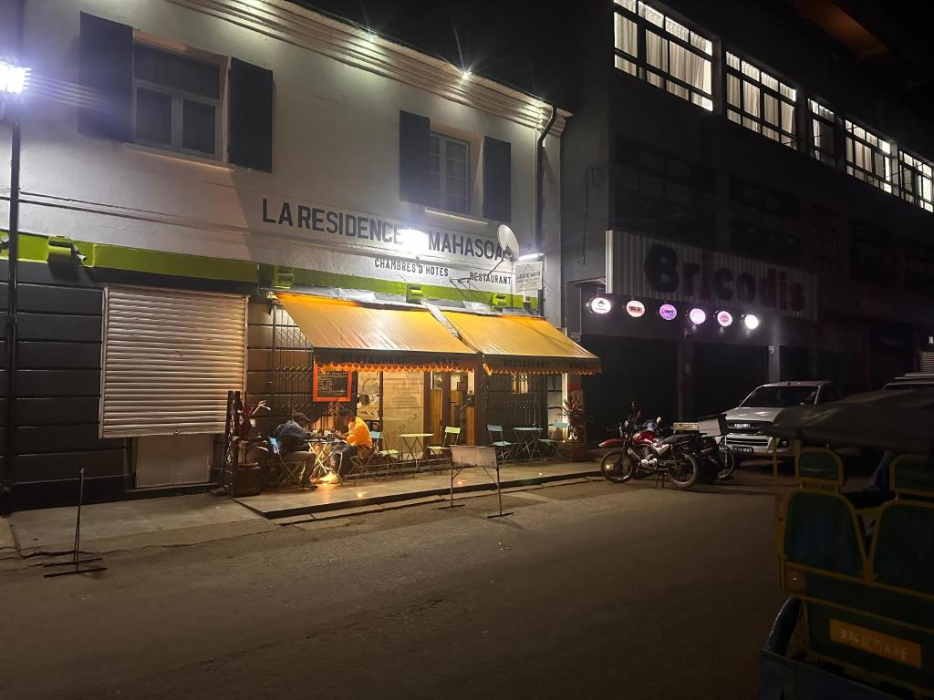 una tienda frente a un edificio por la noche en La Residence Mahasoa, en Antsirabe