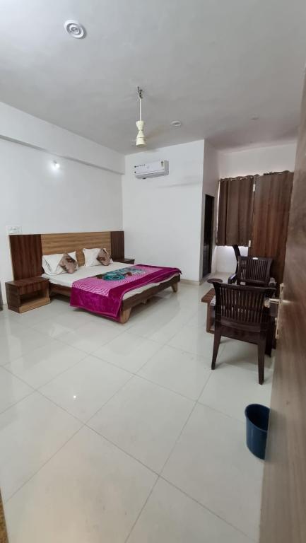 sypialnia z łóżkiem i krzesłem w pokoju w obiekcie Hotel Mayur Inn w mieście Udaipur