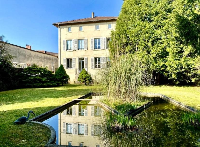 une maison et un étang en face d'un bâtiment dans l'établissement Chambre privée dans spacieuse maison de maître, à Cousancelles