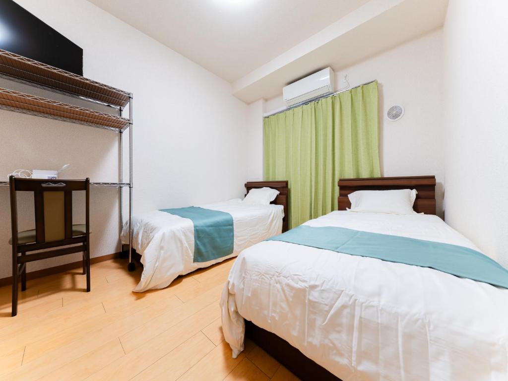 a bedroom with two beds and a green curtain at Shinjuku/Shin-Okubo Sta 2min walk/Kabukicho 5 min in Tokyo