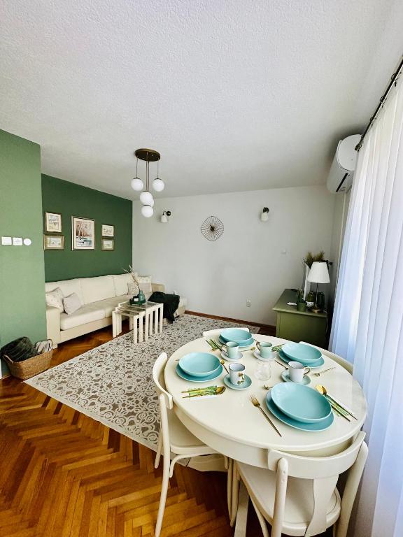 a living room with a table with blue plates on it at Cozy Suite Apartment in Visoko