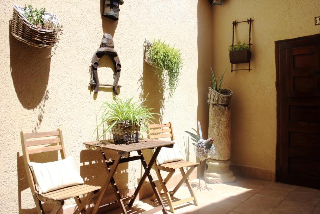 a patio with a table and chairs and potted plants at Casa Rural Bellamonte in Belmonte