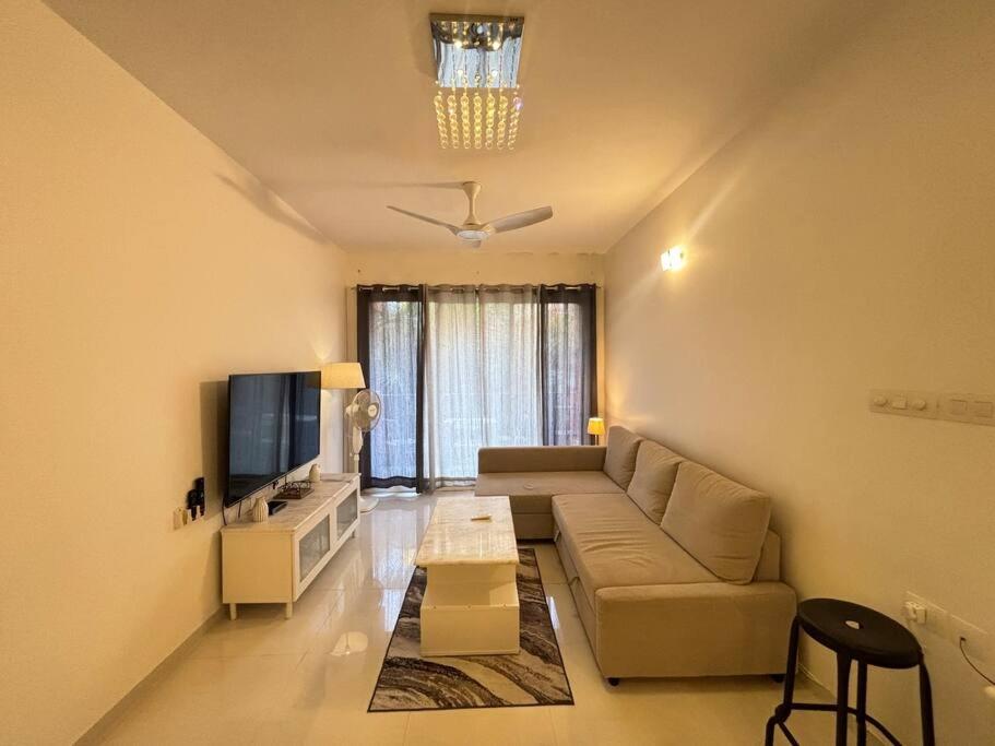 莫尔穆冈Elegant 2 BHK, Pool Front, Zennova Stays的带沙发和电视的客厅