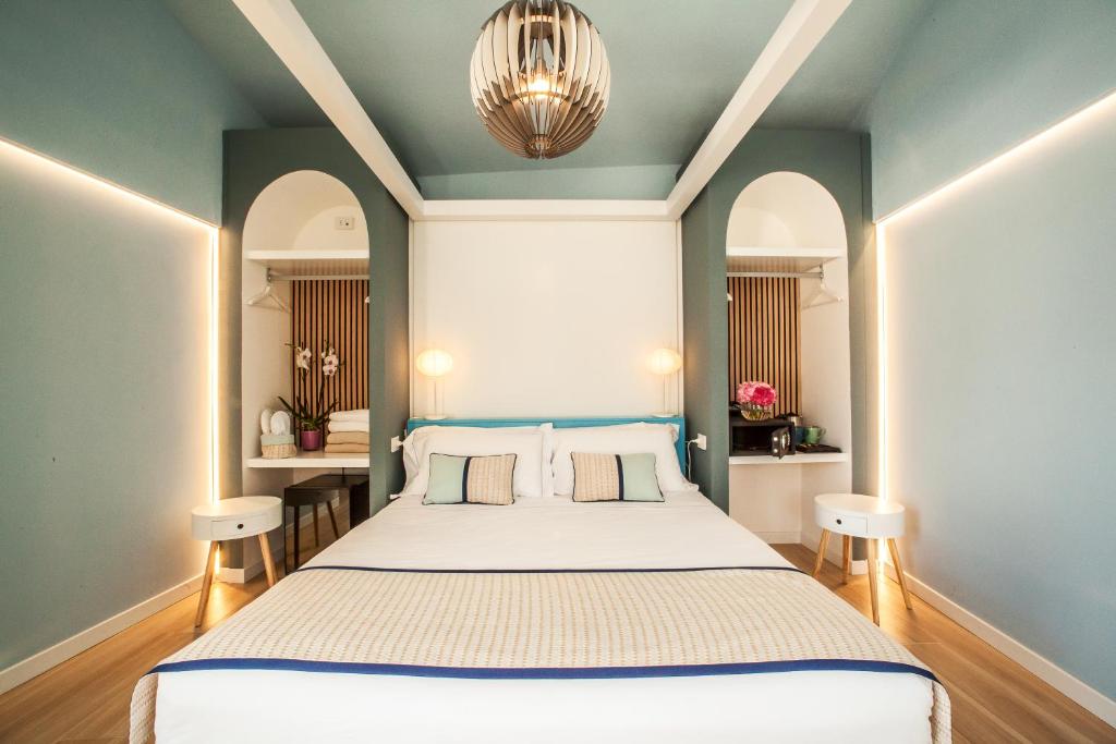 a bedroom with a large bed with blue walls and a chandelier at New Barcavela in Santa Margherita di Pula