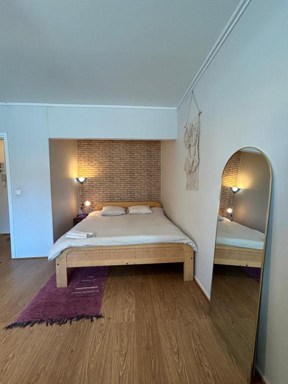 um quarto com uma cama grande e um espelho em Studio apartment near the center em Jyväskylä