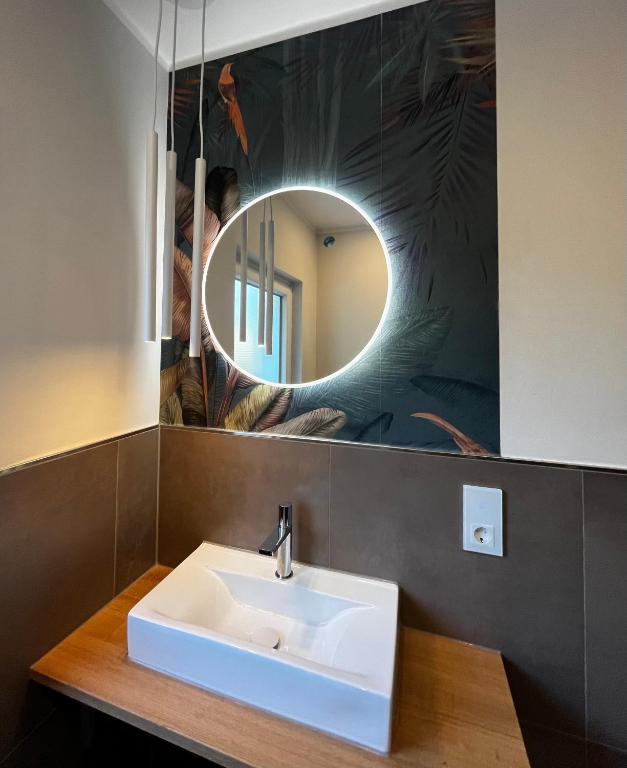 a bathroom with a white sink and a mirror at Ferienhaus Windmühlenweg mit großem sonnigen Garten -Neu- in Spenge