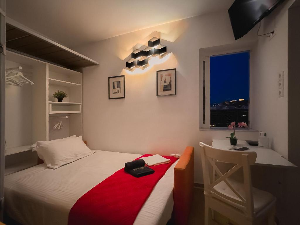 um quarto com uma cama, uma secretária e uma janela em The Terrace with Acropolis & Athens view em Atenas