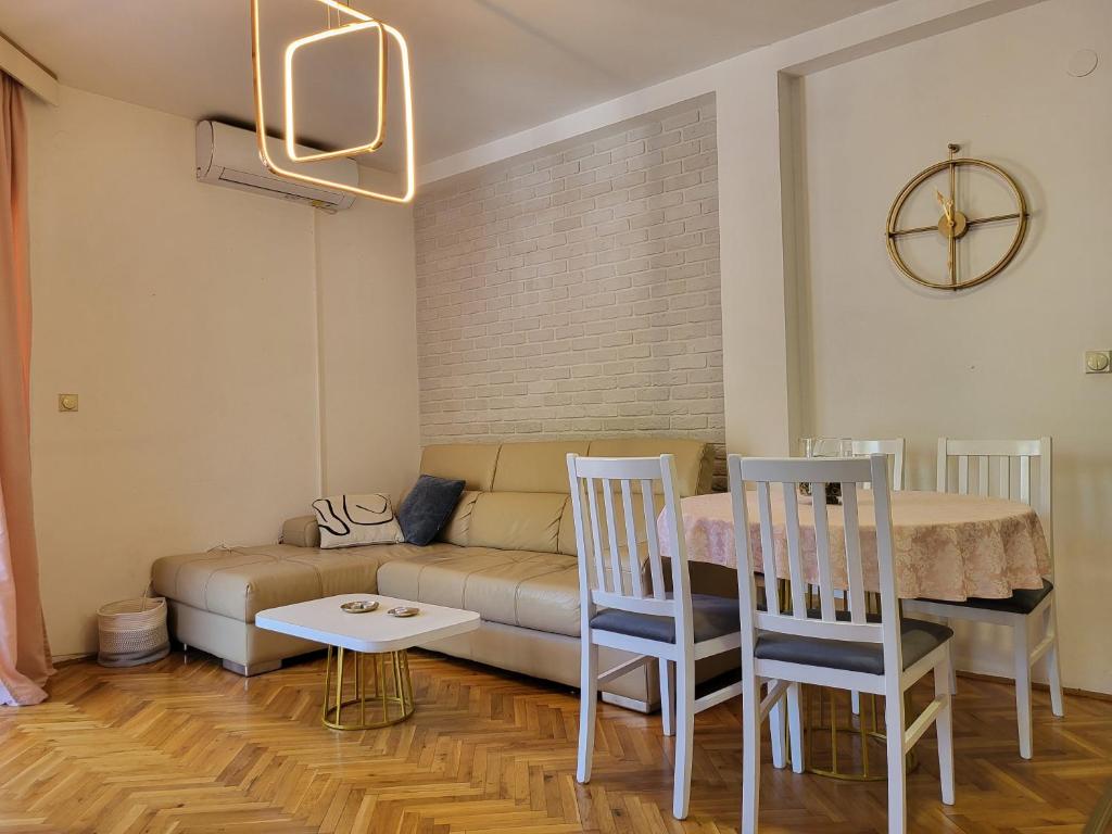 a living room with a couch and a table and chairs at Apartman Katica in Tivat