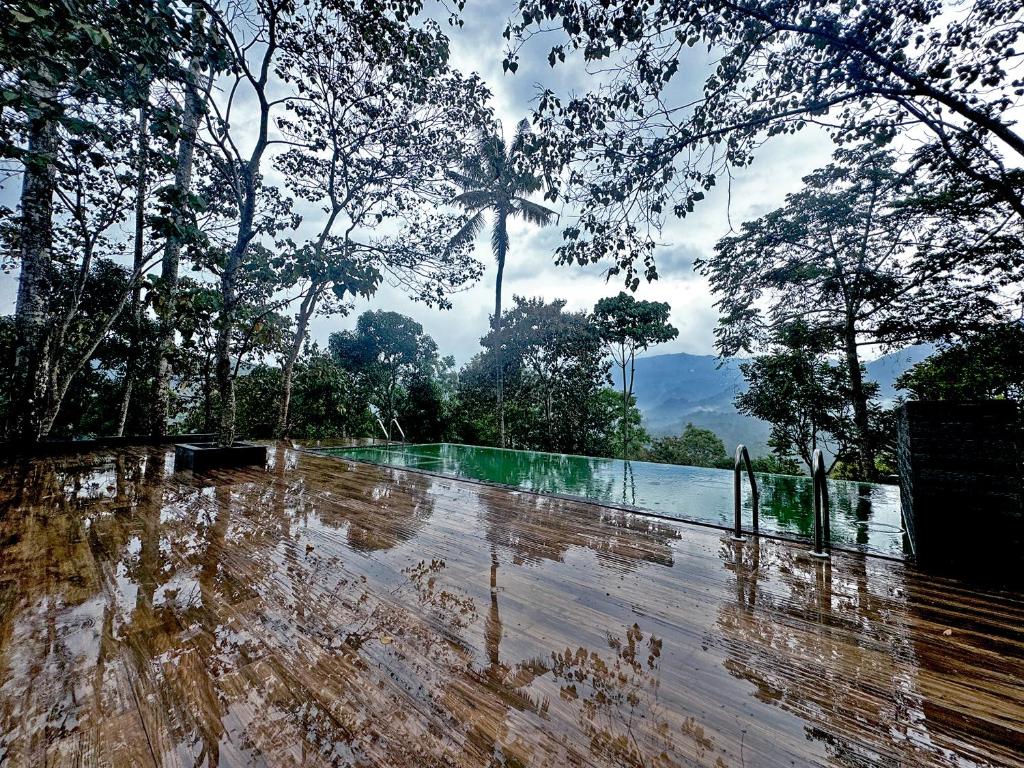 a flooded street with trees and a body of water at Viceroy Luxury Mountain Resort and Spa in Munnar