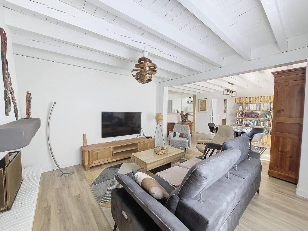 un salon avec un canapé et une télévision dans l'établissement S-Vacances-Soustons Maison 4 personnes centre-ville avec joli jardin, à Soustons