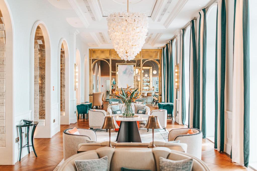 a lobby with a table and chairs and a chandelier at Hilton Imperial Dubrovnik in Dubrovnik