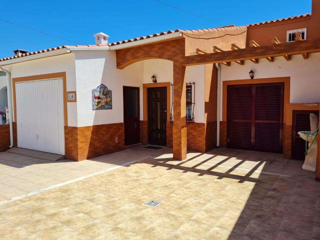 a house with two garage doors and a patio at Casa do Sérgio in Luz